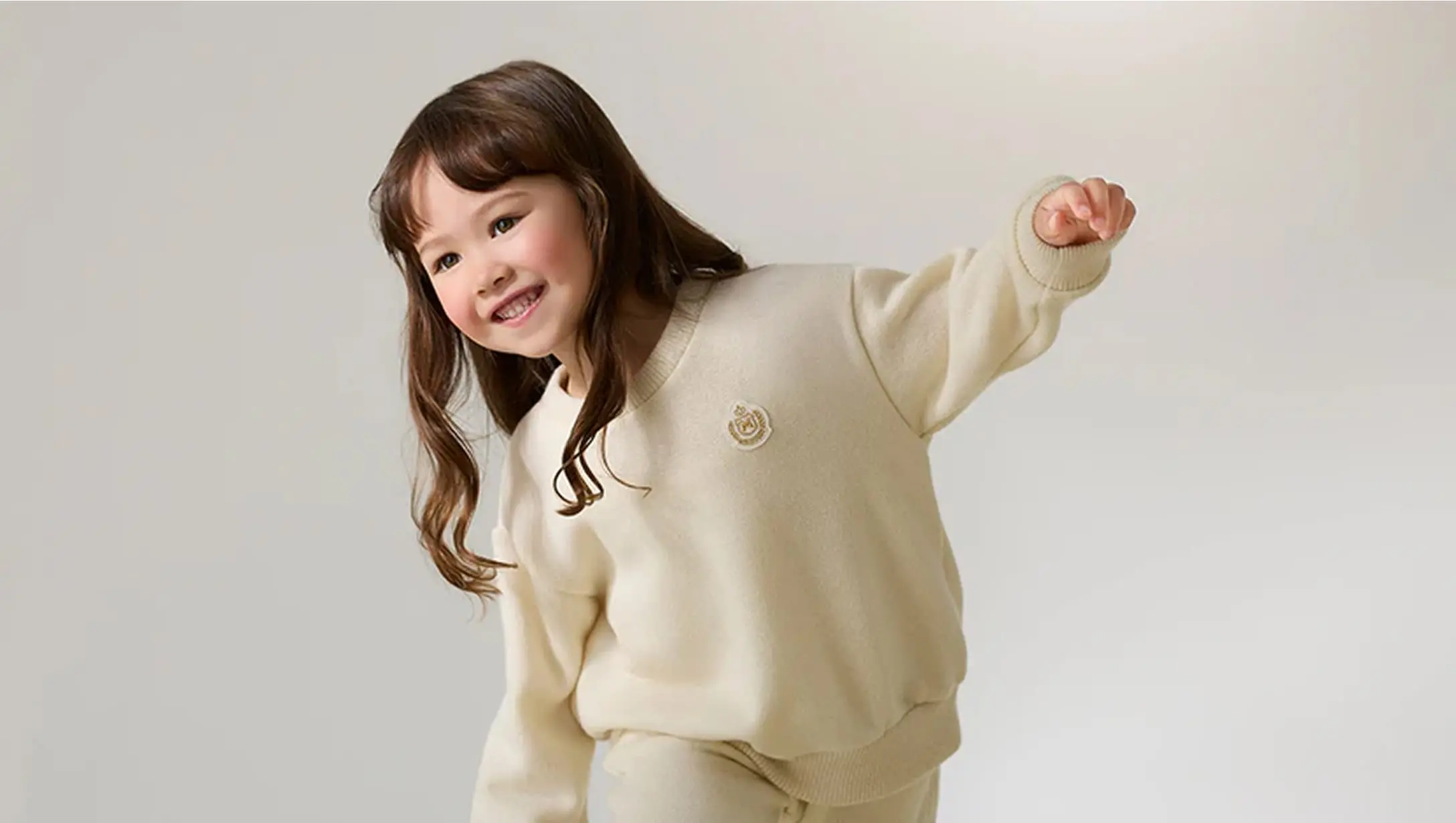 白いセーターを着て笑顔を見せる女の子