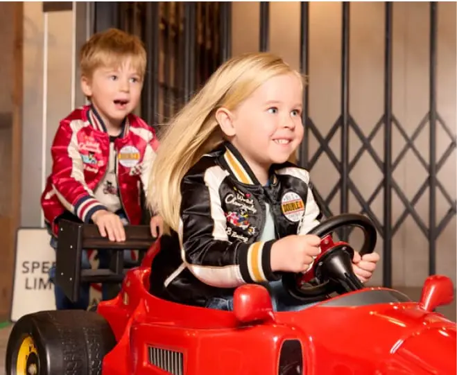 赤い乗り物に乗って遊ぶ子どもたち