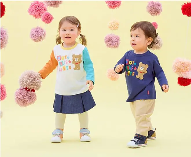 明るい色の洋服を着て笑う子どもたち