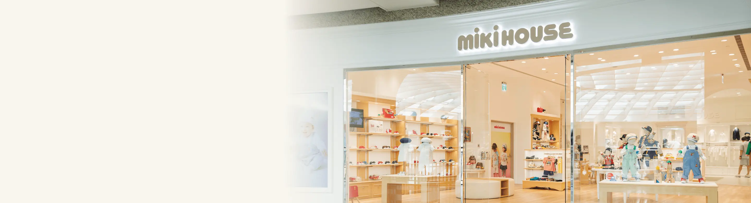 ミキハウスの店舗の外観。ガラス張りのショーウィンドウに「mikiHOUSE」のロゴが表示され、店内には子供服やディスプレイが見える