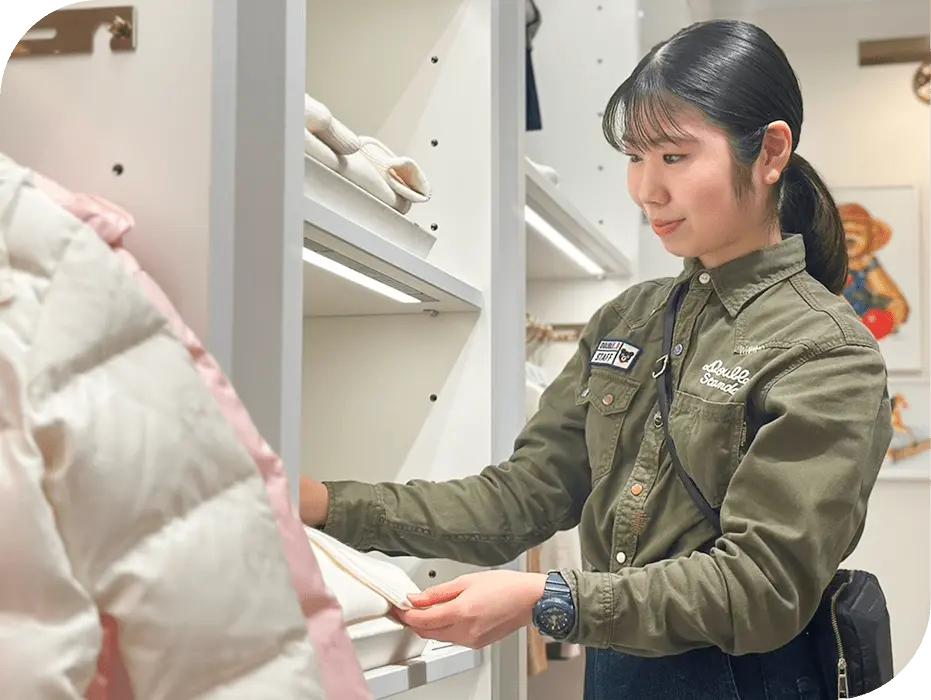 ミキハウスの店舗で棚の商品を丁寧に整えるY.Kさん